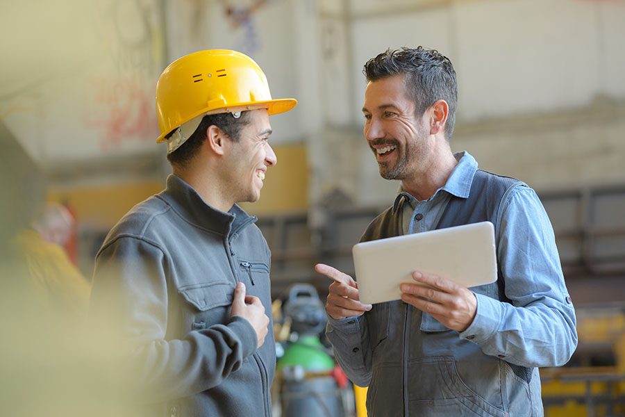 Employee Benefits - Factory Worker Talking with His Manager at the Warehouse