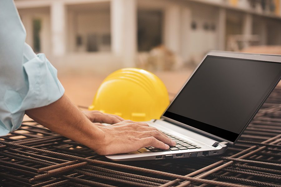 Insurance Quote - View of Contractor Using a Tablet at Construction Jobsite
